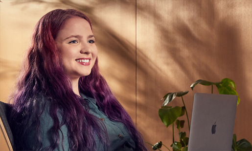 Alexa sitter og jobber på en laptop.
