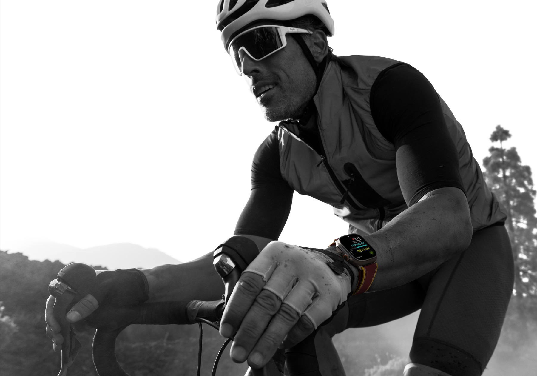 Apple Watch Ultra 4を装着してロードバイクに乗っている人物。Apple Watchの画面にはサイクリングの測定値が表示されている