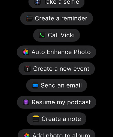 Ecrã com pedidos para a Siri AI, incluindo: «Take a selfie», «Create a reminder», «Call Vicki», «Rotate photo left», «Create a new event», «Send an email», «Resume my podcast», «Create a note» e «Add photo to album»."