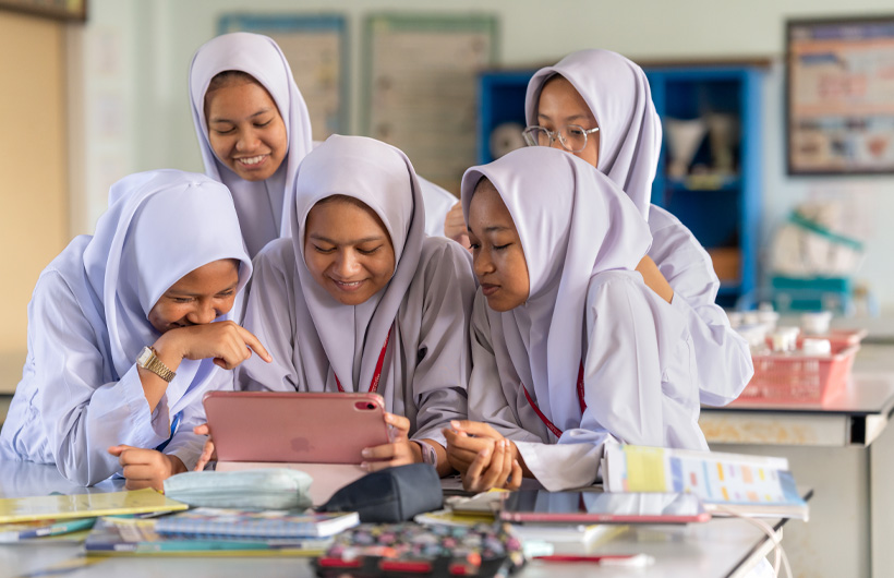 Sekolah Seri Puteri의 학생들이 열역학에 대해 배운 것을 선보이기 위해 함께 iMovie로 영상을 제작하고 있습니다.