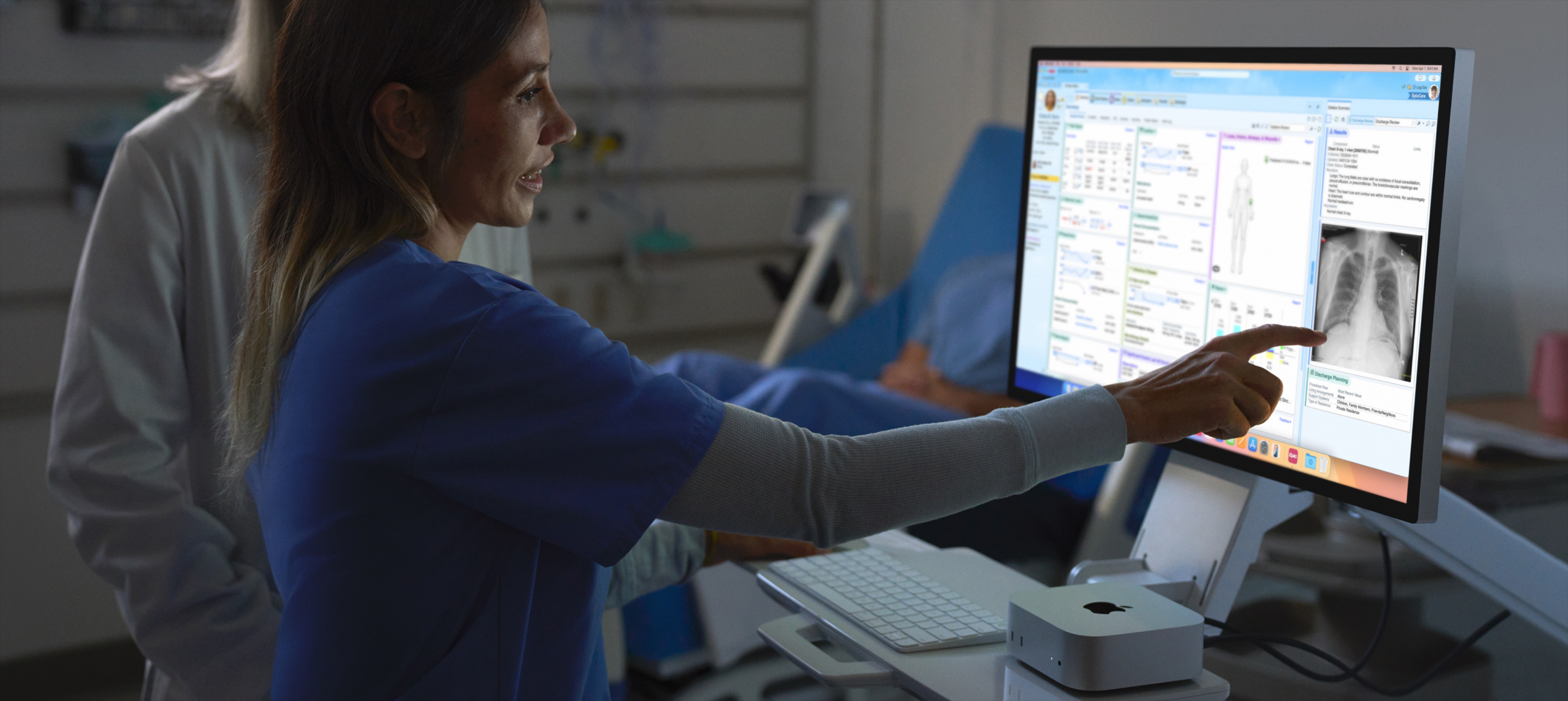 Immagine di un’infermiera che indica la radiografia di un paziente su un Mac.