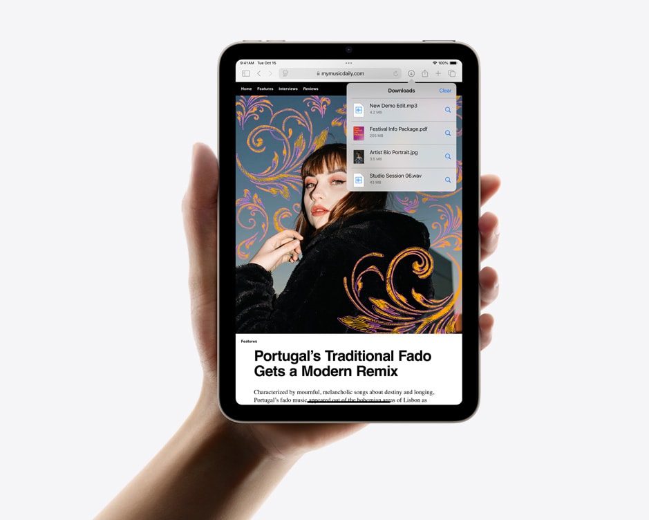 iPad mini ținut într-o mână în dispunere verticală, afișând funcția de descărcări în Safari.