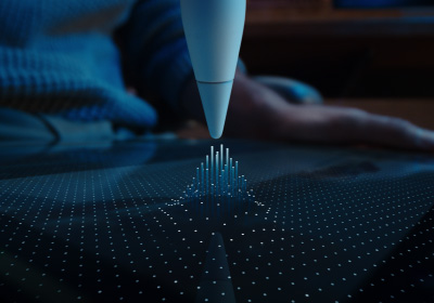 Apple Pencil Pro este îndreptat în jos, către un ecran. Ecranul este plin de puncte care se înșiruie în sus și urmează vârful unui Apple Pencil Pro, reprezentând felul în care funcția de planare a Apple Pencil conectează Apple Pencil Pro la iPad chiar înainte de a atinge ecranul.