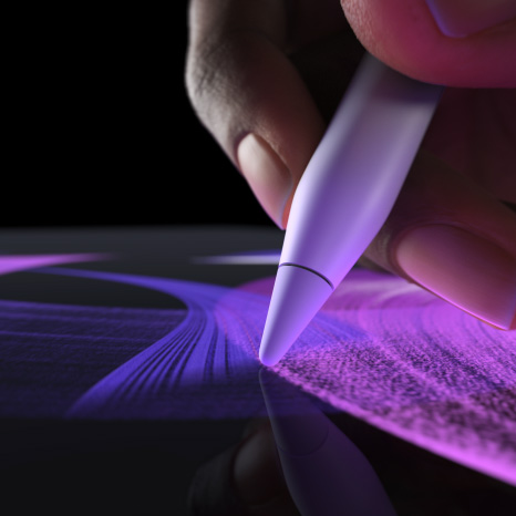 Apple Pencil Pro, πλαϊνή εξωτερική όψη, λευκό χρώμα, χέρι που κρατά το Pencil και σχεδιάζει μια πινελιά σε φωτεινό μπλε