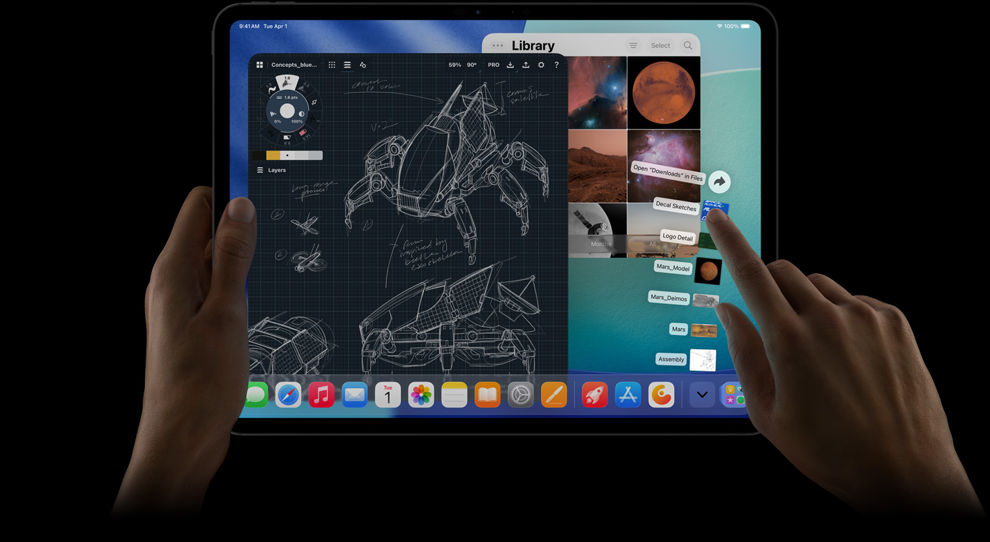 iPad Pro, μπροστινή εξωτερική όψη, οριζόντιος προσανατολισμός, δεξί χέρι κάνει χειρονομίες πάνω από αρχεία του φακέλου λήψεων που σχηματίζουν βεντάλια, οθόνη που εμφανίζει το περιβάλλον εργασίας του PadOS 26 με πολλαπλά ανοιχτά apps, συμπεριλαμβανομένου ενός app επεξεργασίας φωτογραφιών με λεπτομερή σχέδια και χειρόγραφες σημειώσεις για ένα ρομπότ και πολλαπλά στάδια σχεδιασμού, και Βιβλιοθήκη φωτογραφιών