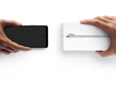 Manos intercambiando teléfonos, dispositivo Android sin caja a la izquierda, iPhone Air nuevo en su caja a la derecha