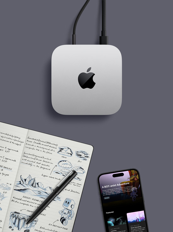 Sidabro spalvos „Mac mini“ su „Apple“ logotipu vaizdas iš viršaus, jis padėtas ant darbo stalo šalia „iPhone“, rašiklio ir atversto užrašų knygelės su ranka rašytomis pastabomis