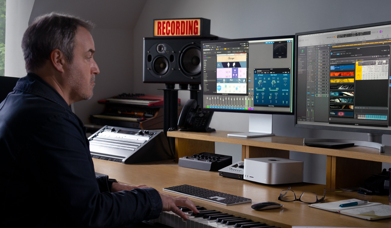 Una persona che usa un piano per creare mix audio con Mac Studio e Studio Display