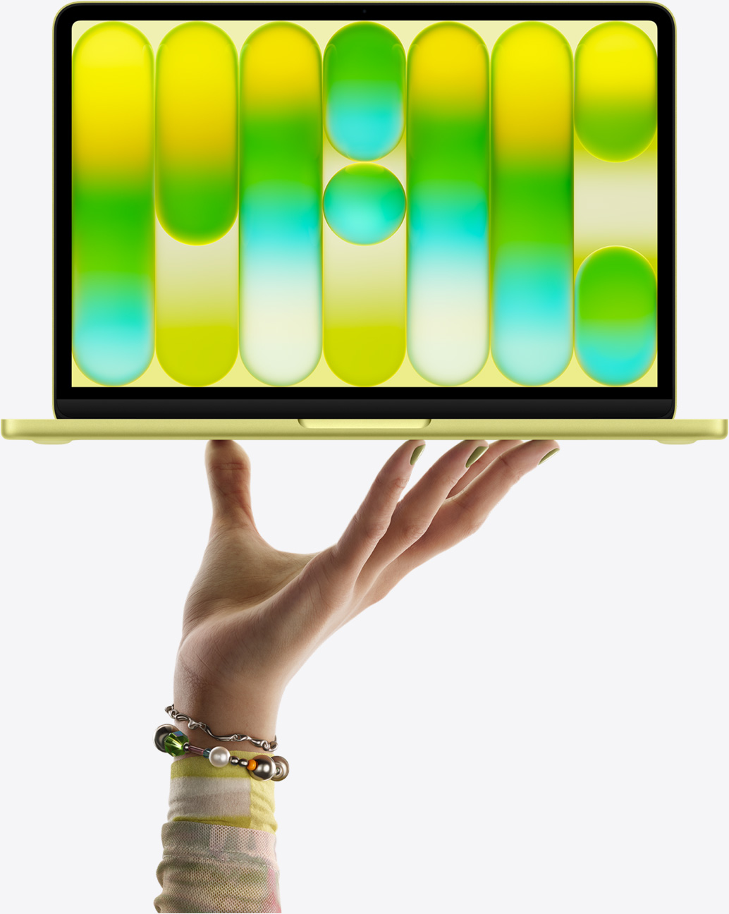 開いた手の指先がシトラスのMacBook Neoをバランス良く支えている。画面にはカラフルで抽象的なパターンが表示されている