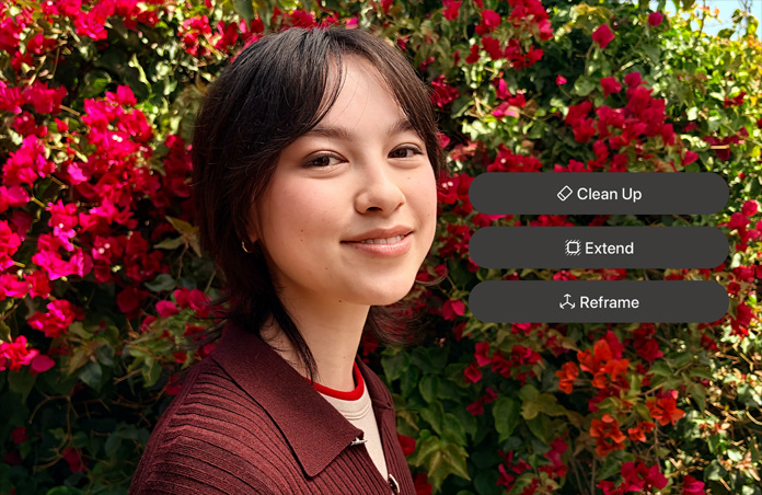 Foto de una persona sonriente de pelo castaño, con un jersey marrón, flores rojas a su alrededor, demostración de la edición de fotos mediante IA con las opciones Limpiar, Extender y Reencuadrar sobre la foto
